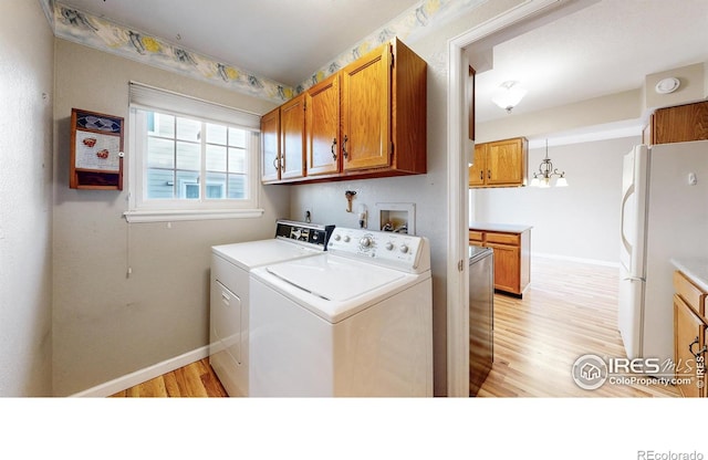 laundry area featuring cabinets, light hardwood / wood-style flooring, and independent washer and dryer