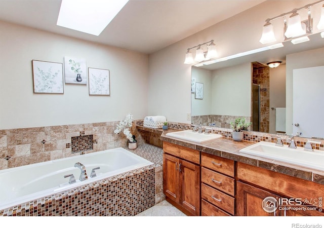 bathroom featuring vanity, plus walk in shower, and a skylight