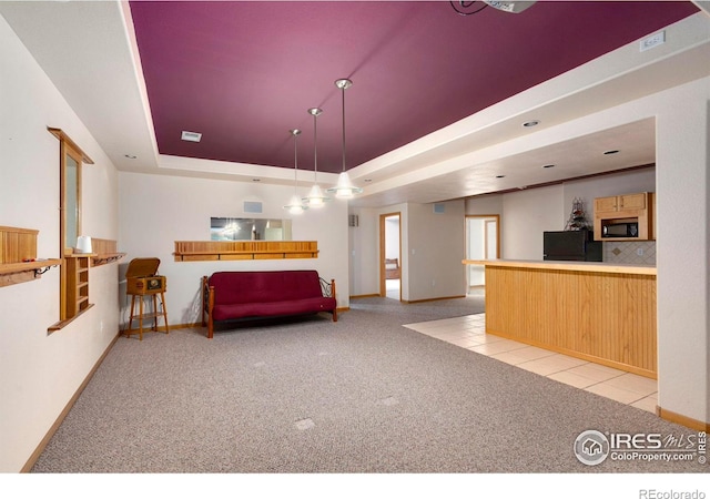 interior space with a tray ceiling and light carpet