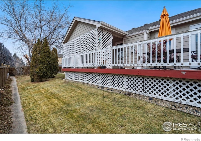 back of property with a wooden deck and a yard