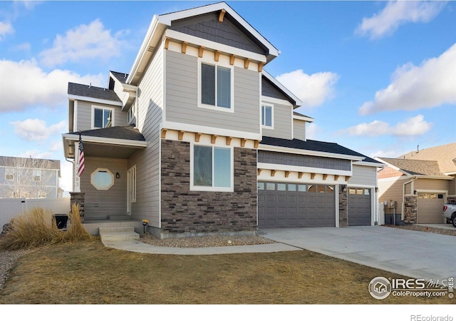 view of front of home featuring a garage, stone siding, and driveway