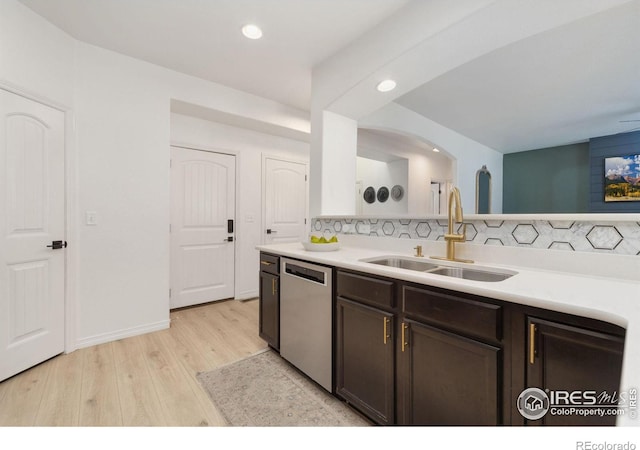 kitchen with dark brown cabinetry, dishwasher, light wood-style flooring, light countertops, and a sink