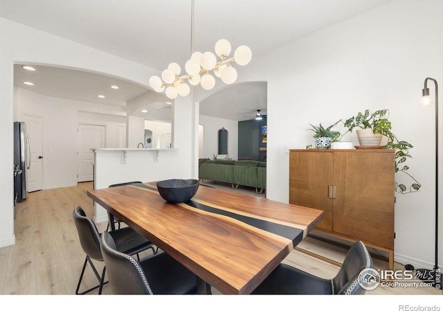 dining space featuring arched walkways, recessed lighting, light wood-style floors, a ceiling fan, and baseboards