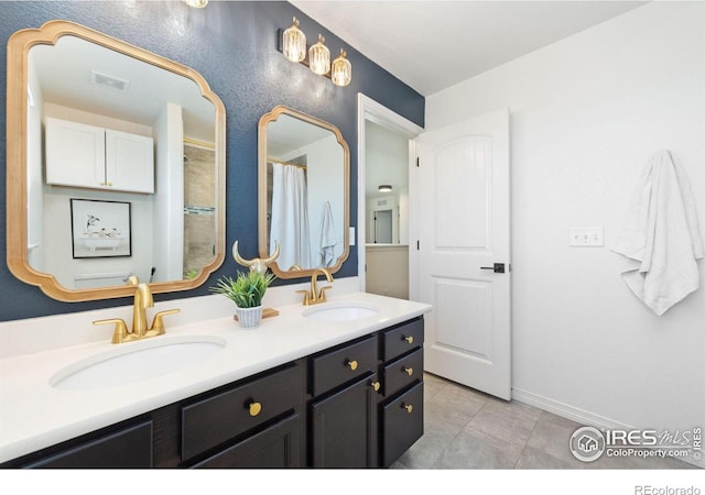 full bath featuring double vanity, a sink, visible vents, and baseboards