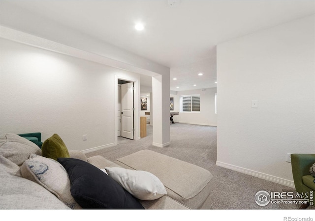 carpeted living area with recessed lighting and baseboards