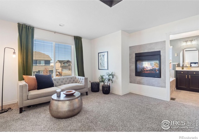 living area featuring baseboards, carpet flooring, and a multi sided fireplace