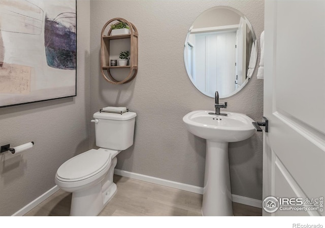 bathroom featuring hardwood / wood-style flooring and toilet