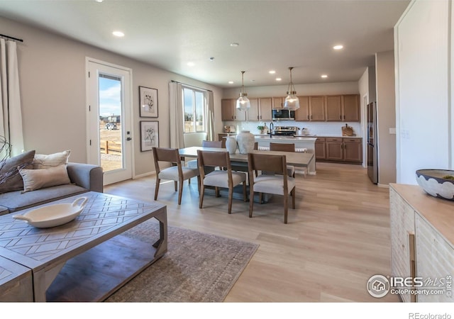 living room featuring sink and light hardwood / wood-style flooring