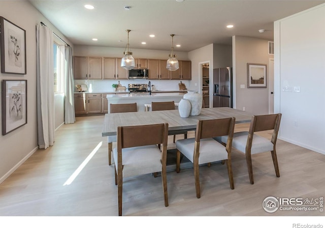 dining room featuring sink and light hardwood / wood-style flooring