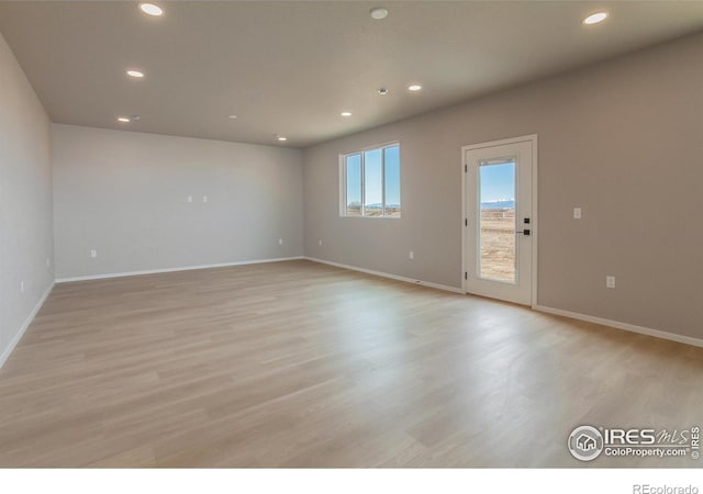 unfurnished room with recessed lighting, baseboards, and light wood-style flooring