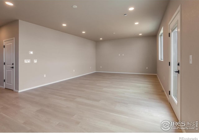 spare room featuring recessed lighting, baseboards, and light wood finished floors