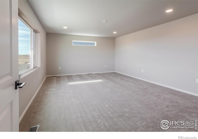 carpeted spare room featuring visible vents, recessed lighting, and baseboards