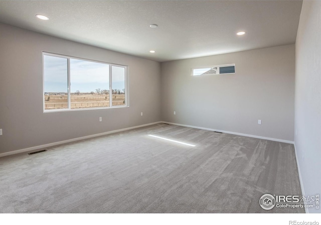 carpeted empty room with visible vents, recessed lighting, and baseboards