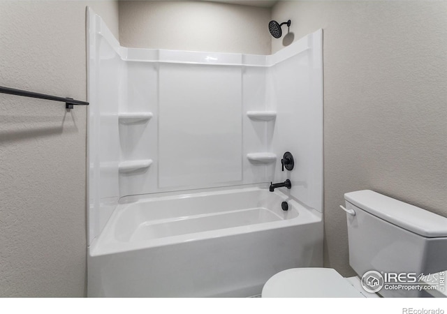 bathroom with toilet and a textured wall