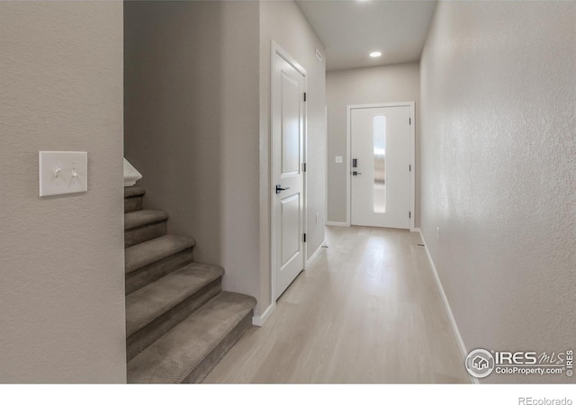 doorway to outside featuring stairway, light wood-style flooring, and baseboards