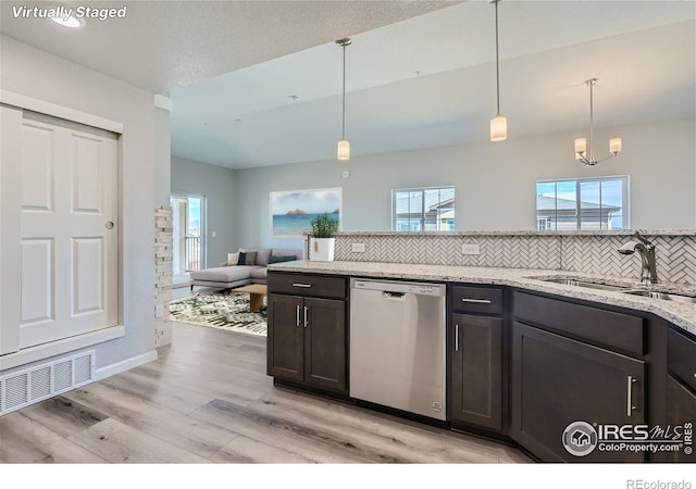 kitchen with decorative light fixtures, dishwasher, sink, dark brown cabinetry, and light stone counters