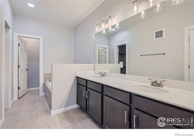 bathroom with a bathing tub, tile patterned floors, and vanity