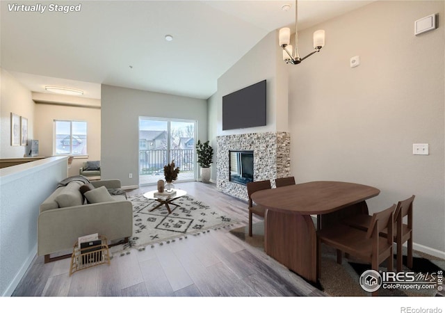 living room featuring high vaulted ceiling, a healthy amount of sunlight, wood-type flooring, and a tile fireplace