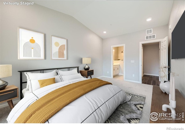 bedroom with lofted ceiling and ensuite bath