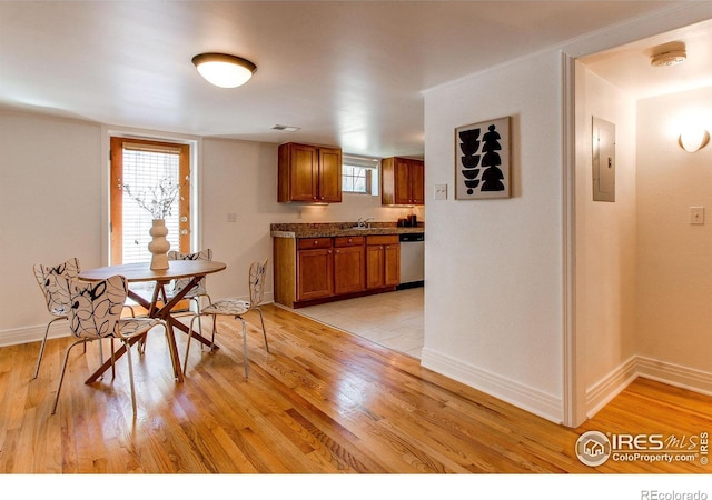 dining room with sink, electric panel, and light hardwood / wood-style floors