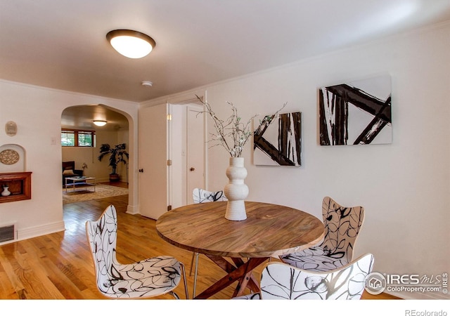 dining area featuring crown molding and light hardwood / wood-style floors