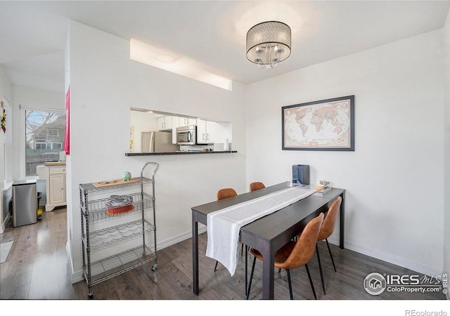 dining space featuring a notable chandelier and dark wood-type flooring