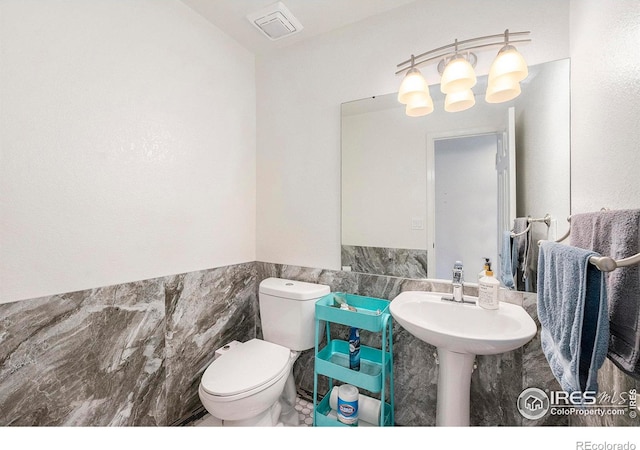 bathroom with tile walls and toilet