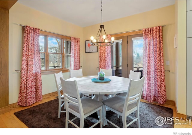 dining area with a chandelier and wood finished floors