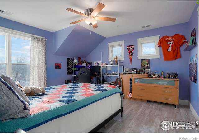 bedroom featuring a ceiling fan, visible vents, vaulted ceiling, and light wood-type flooring