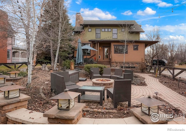 back of house featuring a fire pit and a patio