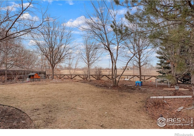 view of yard with a rural view and fence