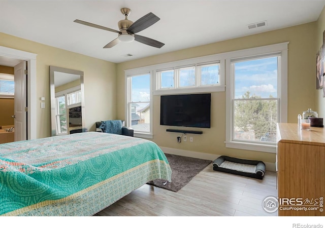 bedroom featuring baseboards, visible vents, ceiling fan, and light wood finished floors