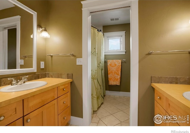 bathroom with vanity, baseboards, visible vents, and tile patterned flooring