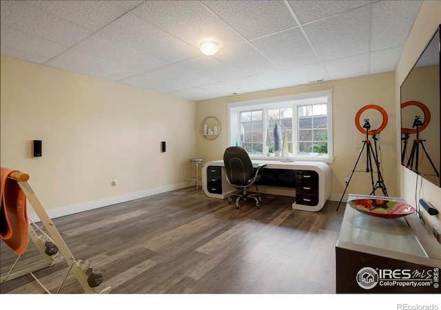 office featuring baseboards, dark wood finished floors, and a drop ceiling