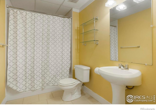 bathroom with a paneled ceiling, tile patterned floors, toilet, and visible vents