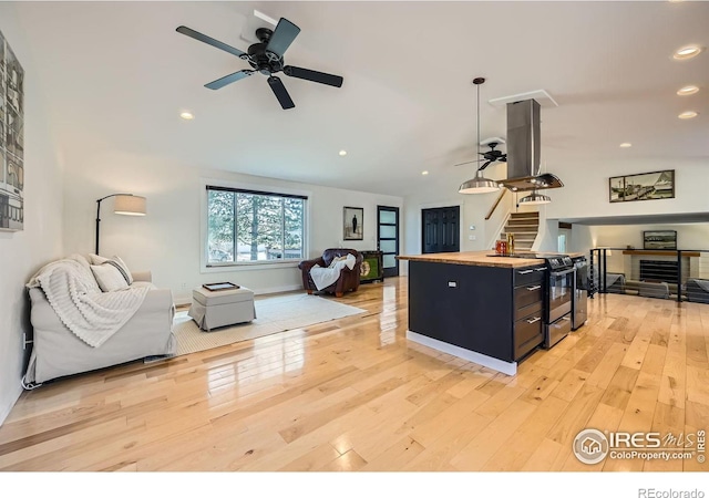 living area featuring recessed lighting, stairway, ceiling fan, and light wood finished floors