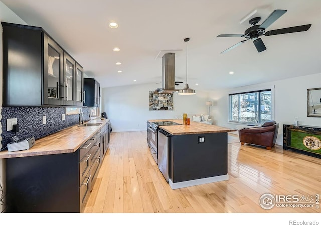 kitchen featuring a sink, island exhaust hood, stainless steel electric stove, and butcher block countertops