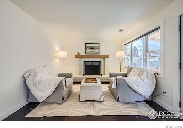 living room featuring visible vents, a fireplace, and baseboards