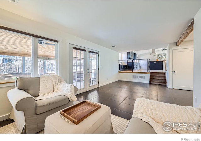 living area featuring baseboards, visible vents, ceiling fan, french doors, and dark tile patterned floors