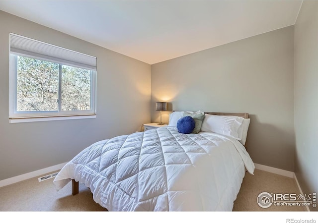 carpeted bedroom featuring visible vents and baseboards