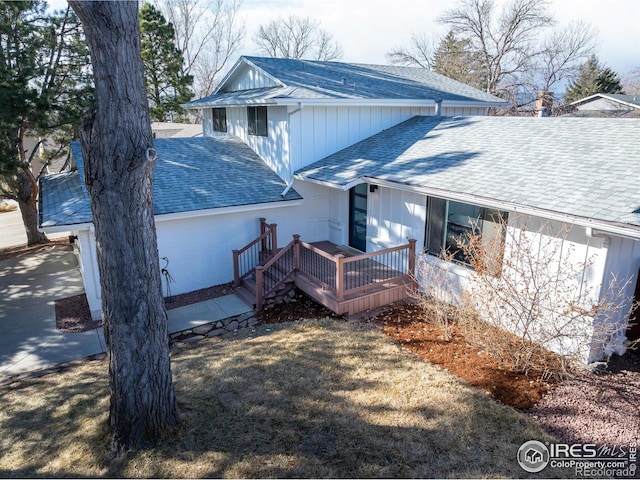 rear view of property with roof with shingles