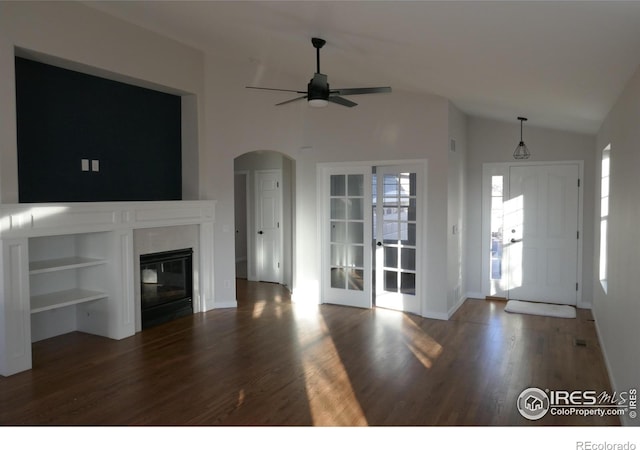 unfurnished living room featuring dark wood-type flooring, a fireplace, ceiling fan, and vaulted ceiling