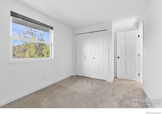 unfurnished bedroom with light colored carpet and a closet