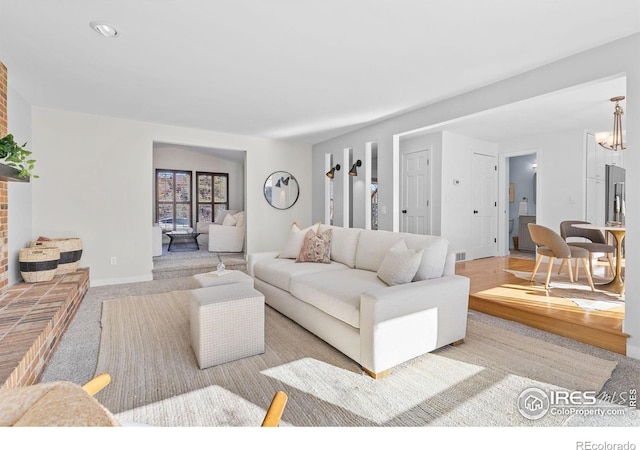 carpeted living room featuring a notable chandelier