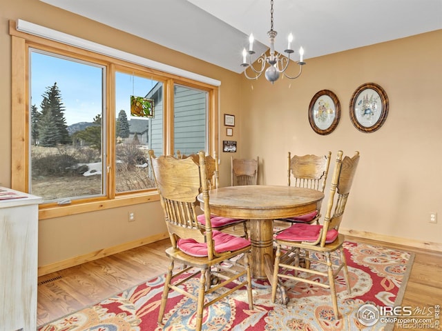 dining space with a chandelier and light wood-type flooring