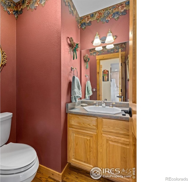 bathroom with hardwood / wood-style flooring, vanity, and toilet