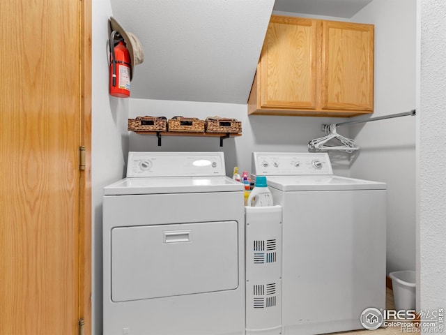 clothes washing area featuring cabinets and washer and dryer