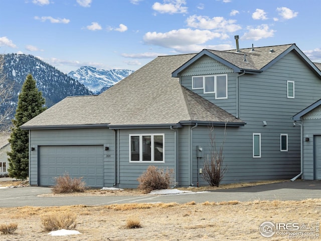 back of house featuring a garage and a mountain view