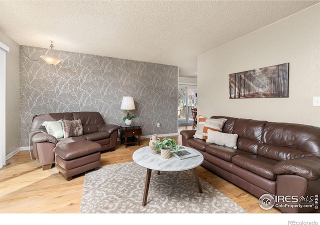 living room featuring wood-type flooring and a textured ceiling