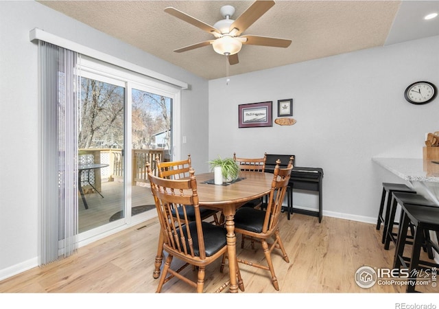 dining space featuring ceiling fan, a textured ceiling, and light wood-type flooring